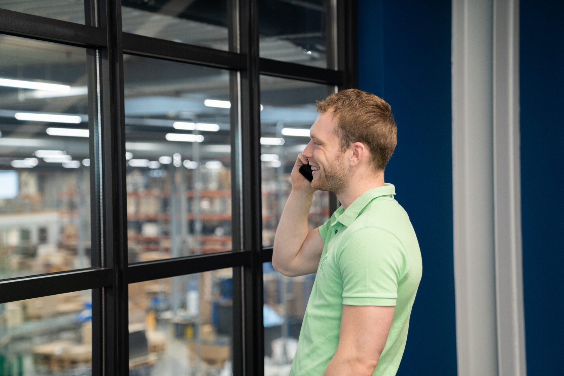 Locatiemanager van Facility Spot belt lachend op kantoor